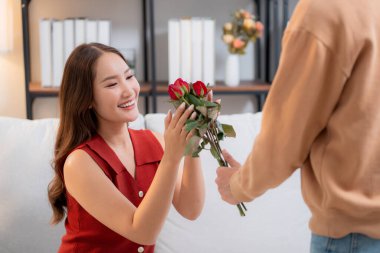 Sevgililer Günü 'nü ya da yıldönümünü evde kutlayan Asyalı mutlu bir kadın. Neşeli sürpriz hediyeye aşık genç bir çift. Romantik tatil..