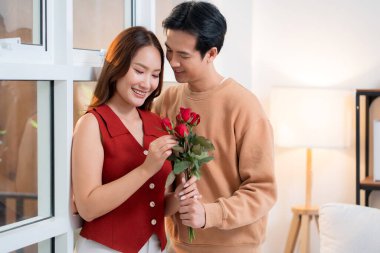 Sevgililer Günü 'nü ya da yıldönümünü evde kutlayan Asyalı mutlu bir kadın. Neşeli sürpriz hediyeye aşık genç bir çift. Romantik tatil..