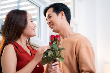 Sevgililer Günü 'nü ya da yıldönümünü evde kutlayan Asyalı mutlu bir kadın. Neşeli sürpriz hediyeye aşık genç bir çift. Romantik tatil..