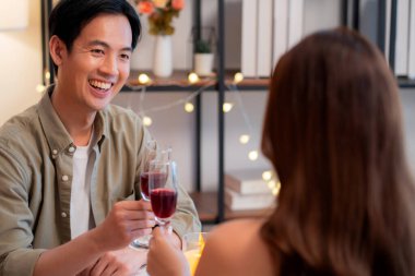 Romantik akşam yemeğinde kadeh tokuşturan mutlu Asyalı çift Sevgililer Günü 'nü ya da yıldönümünü kutluyor, restoran, aşk ve romantizm, flört ve ilişkinin tadını çıkarıyor..