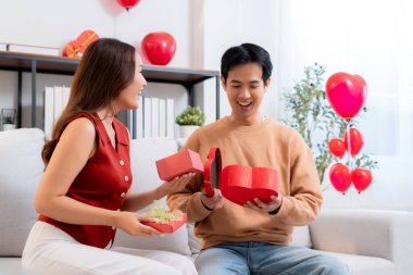 Romantik Asyalı çift, evde doğum günü ya da bayram kutlaması için kalp hediye kutusu veriyor ve alıyor. Sevgililer günü ya da tatilini aşkla kutluyor, romantik sevgililer günü festivali, heyecan hissediyorlar..