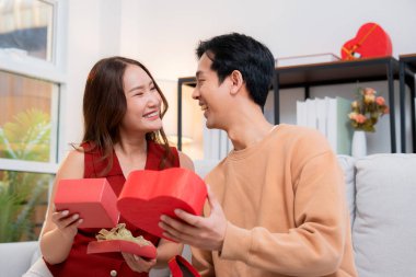 Romantik Asyalı çift, evde doğum günü ya da bayram kutlaması için kalp hediye kutusu veriyor ve alıyor. Sevgililer günü ya da tatilini aşkla kutluyor, romantik sevgililer günü festivali, heyecan hissediyorlar..