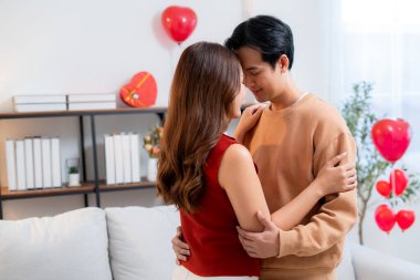 Romantik Asyalı çift başları birbirine değmiş, evde sevgi ve şefkat hissediyorlar. Sevgililer Günü 'nü ya da sevgililer gününü samimiyet ve sevgiyle kutluyorlar..