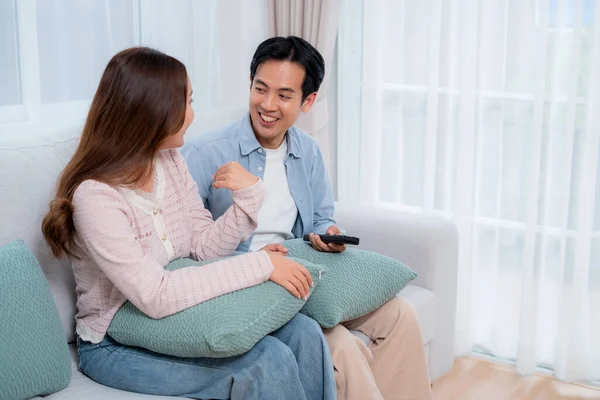 Mutlu Asyalı çift birlikte televizyon seyrediyor. Oturma odasındaki kanepede oturup uzaktan kumandayla film kanalını değiştiriyorlar. Bir çift medya eğlencesinin tadını çıkarıyor..