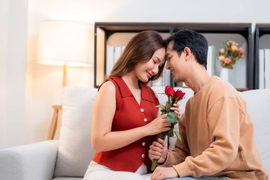 Sevgililer Günü 'nü ya da yıldönümünü evde kutlayan Asyalı mutlu bir kadın. Neşeli sürpriz hediyeye aşık genç bir çift. Romantik tatil..