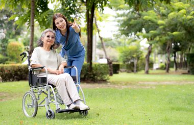 Kafkasyalı genç hemşire dışarıda tekerlekli sandalyede otururken hastayla rahatlıyor, doktor kadın desteği ve hasta ile danışmanlık yapıyor, yaşlı, tıbbi ve teselliye hizmet veriyor..