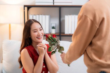 Sevgililer Günü 'nü ya da yıldönümünü evde kutlayan Asyalı mutlu bir kadın. Neşeli sürpriz hediyeye aşık genç bir çift. Romantik tatil..