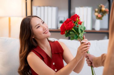 Sevgililer Günü 'nü ya da yıldönümünü evde kutlayan Asyalı mutlu bir kadın. Neşeli sürpriz hediyeye aşık genç bir çift. Romantik tatil..