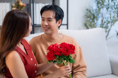 Sevgililer Günü 'nü ya da yıldönümünü evde kutlayan Asyalı mutlu bir kadın. Neşeli sürpriz hediyeye aşık genç bir çift. Romantik tatil..