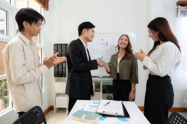 Asyalı iş adamlarının başarı anlaşması için pazarlama sunumundan sonra el sıkışması, işbirliği ile ortaklık pazarlığı, ortakla iş görüşmesi, planlama ve başarı stratejisi.
