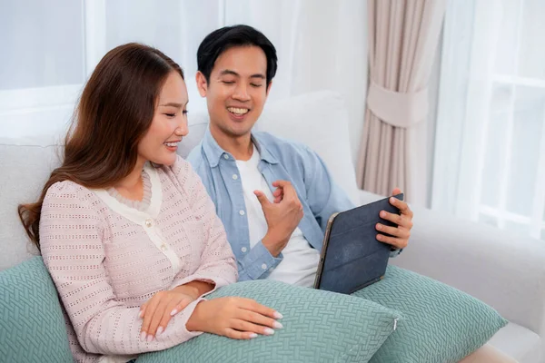 Mutlu Asyalı çiftler, evdeki oturma odasında birlikte otururken, kadın ve erkek evde sanal alemden, teknoloji bağlantısından ve sosyal medya etkileşiminden, ilişkiden ve bağlanmadan bahsediyorlar..