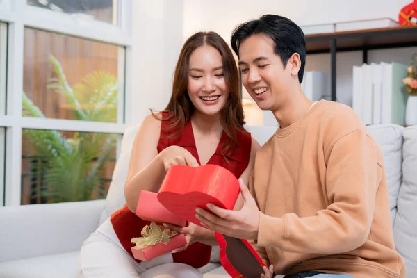 Romantik Asyalı çift, evde doğum günü ya da bayram kutlaması için kalp hediye kutusu veriyor ve alıyor. Sevgililer günü ya da tatilini aşkla kutluyor, romantik sevgililer günü festivali, heyecan hissediyorlar..