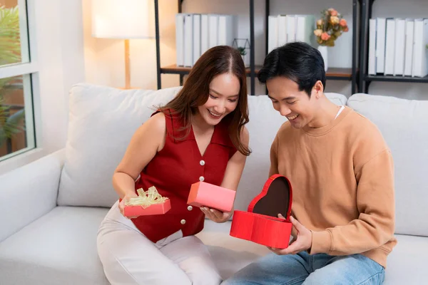 Romantik Asyalı çift, evde doğum günü ya da bayram kutlaması için kalp hediye kutusu veriyor ve alıyor. Sevgililer günü ya da tatilini aşkla kutluyor, romantik sevgililer günü festivali, heyecan hissediyorlar..