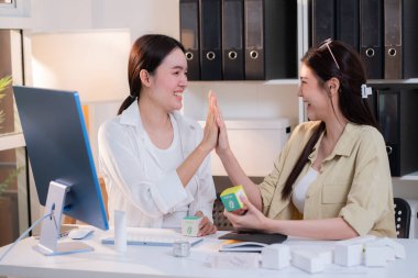 İki Asyalı iş kadını takımı beşlik çaktı. Yapay zeka, üretici yapay zeka için ambalaj geliştirme ve yaratıcı iş planlaması ile başarılı kozmetik ambalaj tasarımı projesini kutladı..