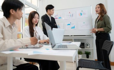 Ofiste planlama ve strateji pazarlaması için grup Asyalı iş adamları toplantısı, grafik ve grafikle finansal veri analizi yaparken, istatistik pazarlamasının sunumu ve açıklaması.