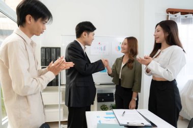 Asyalı iş adamlarının başarı anlaşması için pazarlama sunumundan sonra el sıkışması, işbirliği ile ortaklık pazarlığı, ortakla iş görüşmesi, planlama ve başarı stratejisi.