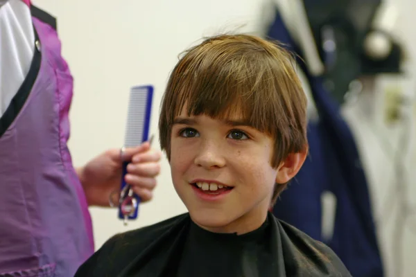 Chico consiguiendo corte de pelo Imagen De Stock