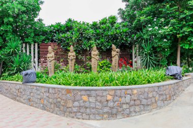 Hyderabad, Telangana Hindistan - 17 08 2019: Büyük Devi Taş Heykeli 'nin Tam Görünümü. Devi 'nin elinden akan su. Arka planda güzel yeşil bitkiler ve ağaçlar var. Telangana / Hyderabad Turizmi.