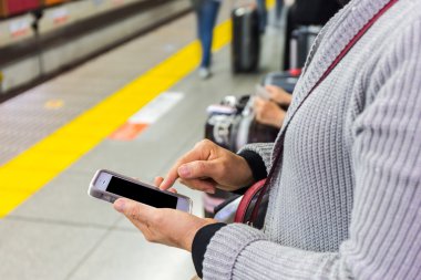 Akıllı cep telefonu kullanan bir kadına yakınlaş.