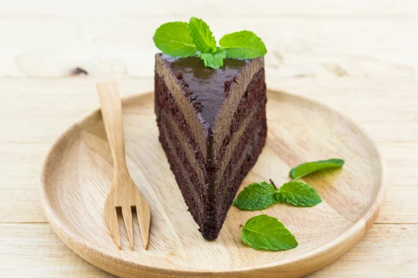 Rebanada de pastel de chocolate en plato de madera . —  Fotos de Stock