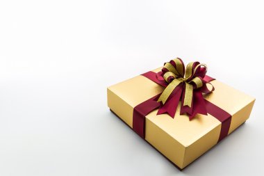 şerit yay ile altın ve kahverengi hediye kutusu.
