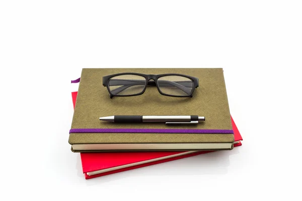 Stylo et lunettes assis sur le livre . — Photo