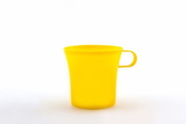 Beyaz arkaplanda sarı plastik bardak. 