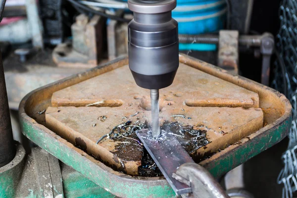 Primer plano técnico industrial que trabaja en una máquina de perforación — Foto de Stock