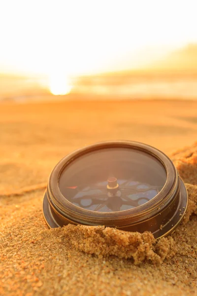 Antika kompass på sanden på stranden Sunrise. — Stockfoto