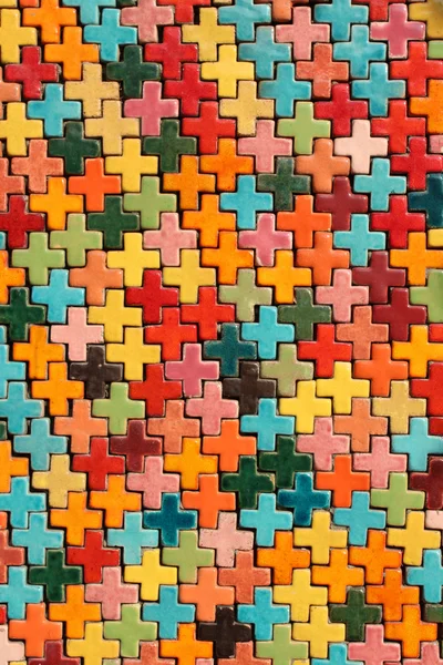 Veelkleurige tegel vorm van een kruis op de muur. — Stockfoto