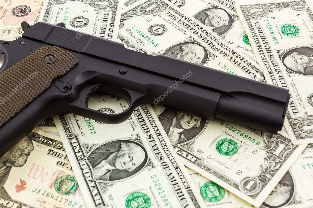 Gun on money background. 