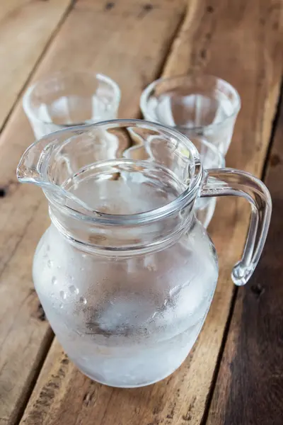 Glass pitcher of water and glass on wooden table. — Stock Photo, Image