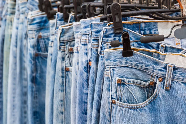 Ряд джинсів і штанів на вішалках . — стокове фото