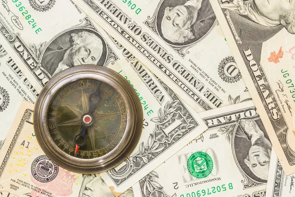 Compass on a heap of paper dollars. — Stock Photo, Image