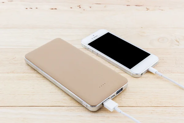 Smartphone med gyllene powerbank. — Stockfoto