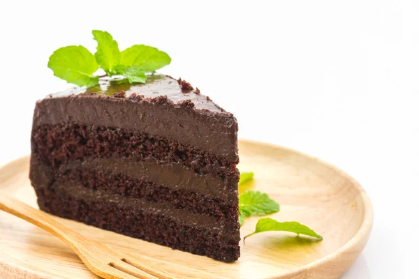 Rebanada de pastel de chocolate en plato de madera . — Foto de Stock