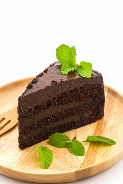 Rebanada de pastel de chocolate en plato de madera . — Foto de Stock