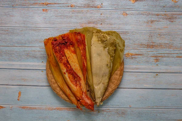 Yeşil soslu tamale ve eski tahtaların üzerinde kırmızı sos. Meksika yemeği