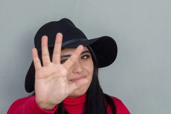 Mexican woman making the give me five sign with her hand. young hispanic