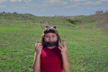 Meksikalı kız dağların önünde maske takıyor. İspanyol ergen