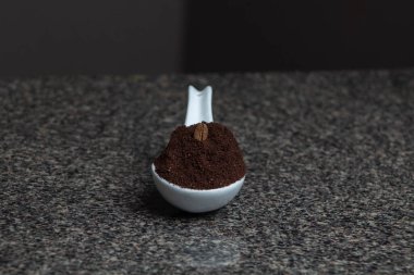 Porselen kaşıkta kahve üzerine kahve tohumu.