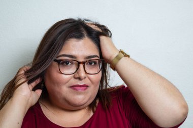 Şişman manken portresi kameraya bakıyor. Şehvetli bir tavır takınıyor ve gözlük takıyor. Meksikalı kadın.