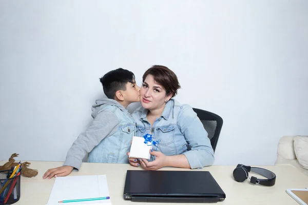 mom and son celebrating mothers day with gift on video call for pandemic and new normal