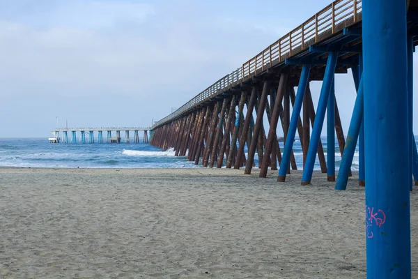 Gün batımında Rosarito 'da insanların olmadığı boş bir sahildeki iskele fotoğrafı.