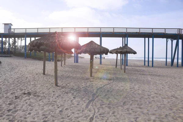 夏季有棕榈树遮阳伞和码头的海滩度假背景 在墨西哥罗萨里托有太阳耀斑 — 图库照片