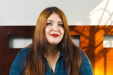 Odada gülümseyen kızıl saçlı güzel bir mankenin portresi. Şişko kadın