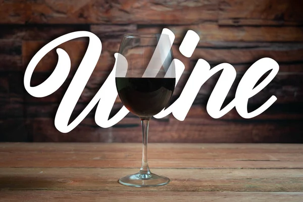 glass of red wine in front of the word wine