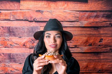 Güzel Latin çiftçi Meksika otunu fasulye taneleriyle gösteriyor.