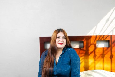 Güzel, şişman, kızıl saçlı, gülümseyen bir kadının portresi.