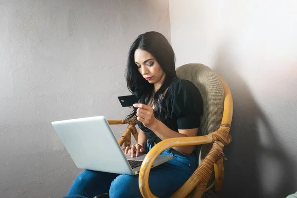 Mujer Latina Sentada Sillón Mostrando Tarjeta Crédito Negra — Foto de Stock